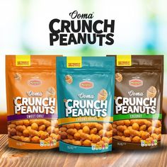 three bags of crunch peanuts sitting on top of a wooden table next to each other