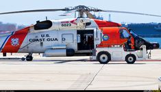 a red, white and blue helicopter is parked on the tarmac