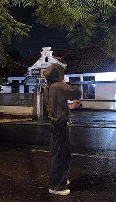 a person in a hoodie is standing on the street