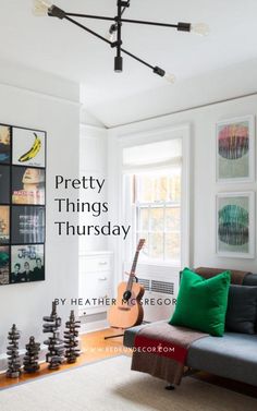 a living room with a couch, guitar and pictures on the wall above it that says pretty things thursday