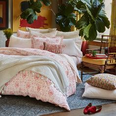 a bed sitting in a bedroom next to a potted plant