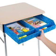 a child's desk with an open drawer on the bottom and two children's books in it