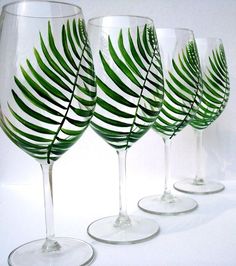 three wine glasses with green leaves painted on them