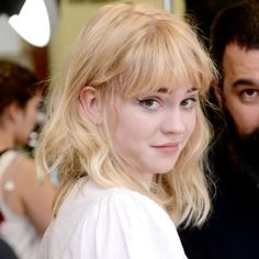 a woman with blonde hair standing next to a man