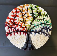 a tree made out of small pieces of broken glass is shown in the shape of a circle