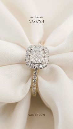 a diamond ring sitting on top of a white bow