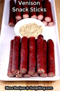 several sausages are on a white plate with dipping sauce in the middle and an image of