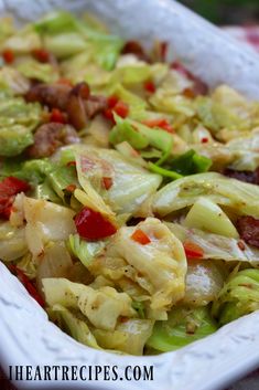 a white dish filled with lettuce and bacon