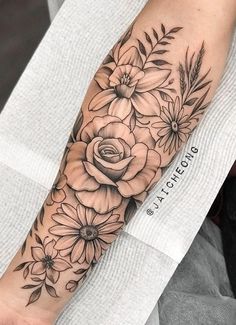 a black and white flower tattoo on the arm