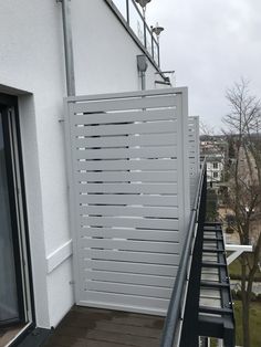 a balcony with white walls and black railings