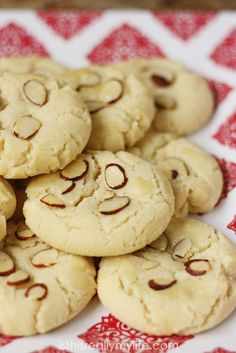 cookies with faces drawn on them sitting on a red and white tableclothed cloth