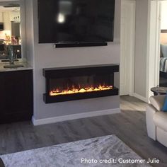 a living room with a couch, television and fire place in the fireplace that is built into the wall