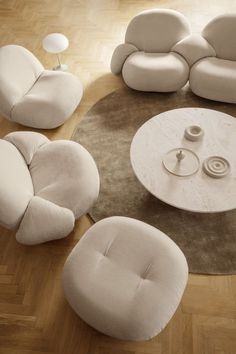 a living room filled with white furniture on top of a hard wood floored floor