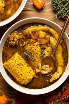 two bowls filled with soup and vegetables on top of a wooden table