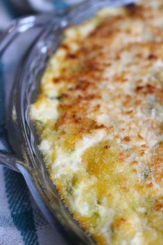 a cheesy casserole dish on a blue and white table cloth