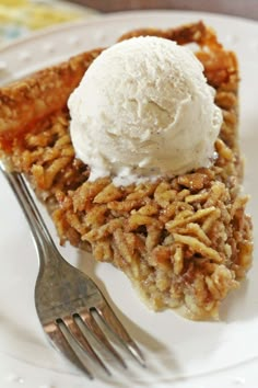 a slice of pecan pie with ice cream on top and a fork next to it