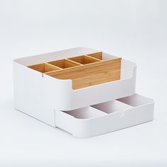 two white drawers with bamboo dividers on each side and one open drawer in the middle