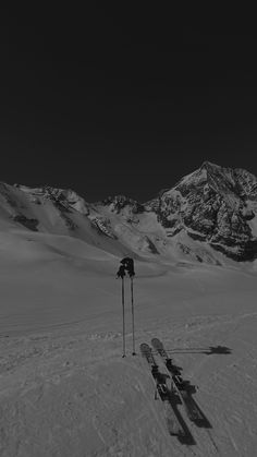 two skis and poles in the snow with mountains in the backgroung