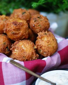 some fried food is in a bowl with dipping sauce on the side and parsley