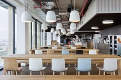 an empty restaurant with wooden tables and white chairs