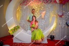 a man and woman posing in front of a fake moon