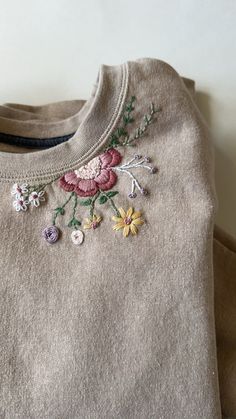 an embroidered sweater with flowers on it