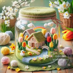 a glass jar with a house in it on a table next to eggs and flowers