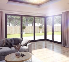 a living room filled with furniture next to a sliding glass door covered in curtains and windows