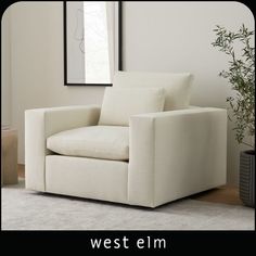 a white chair sitting on top of a rug next to a potted plant