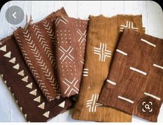 four pieces of cloth with white and brown designs on them, sitting next to each other