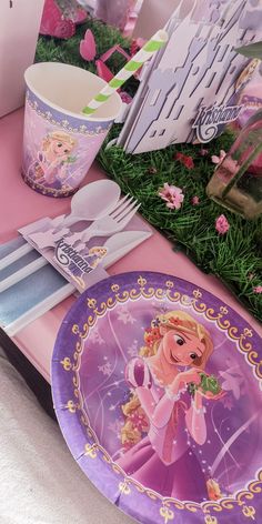 the table is set with plates, cups and utensils for a princess party