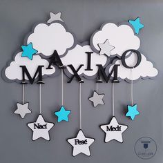 a cloud with stars hanging from it's sides and the word mom spelled in black letters