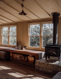 a living room filled with furniture and a fire place in the middle of two windows