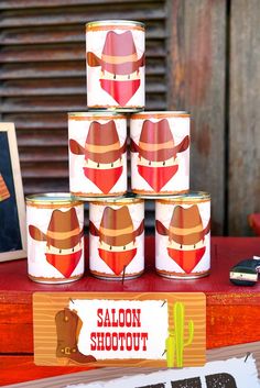 several tins are stacked on top of each other with cowboy hats painted on them