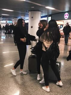 two women are talking to each other at the airport