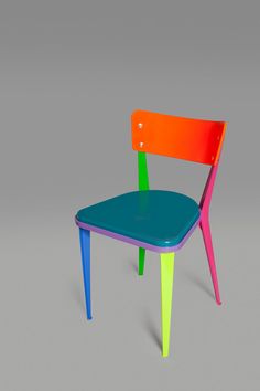 a colorful plastic chair sitting on top of a gray floor