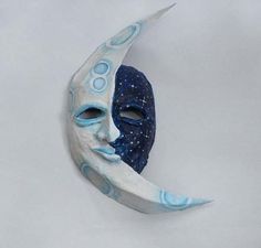 a blue and white mask sitting on top of a moon