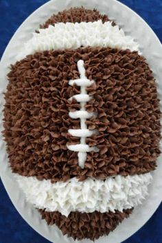 a football cake on a plate with white frosting