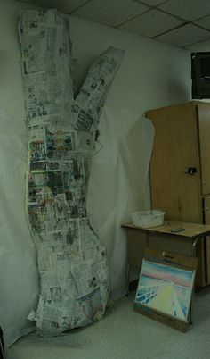 a large piece of newspaper sitting on top of a floor next to a wooden cabinet