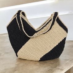 Beige-Black Thick Striped Raffia Tote Bag | Handcrafted & Stylish Elevate your style with this striking beige-black thick striped raffia tote bag, the perfect blend of elegance and practicality. Handcrafted with care, this bag features bold stripes that cover nearly half of the surface, creating a strong visual impact and offering a versatile accessory that meets all your needs. Make every special occasion unforgettable with this thoughtful gift perfect for holidays, anniversaries, and celebrati Rectangular Knitted Straw Travel Bag, Rectangular Knitted Straw Bag For Travel, Knitted Rectangular Straw Bag For Travel, Rectangular Knitted Straw Bag For Everyday Use, Everyday Rectangular Knitted Straw Bag, Everyday Shoulder Bag With Braided Handles And Yarn Material, Trendy Yarn Bags For Everyday Use, Trendy Yarn Bag For Everyday Use, Woven Yarn Bags For Vacation