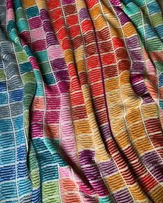 multicolored knitted fabric with small squares and lines on the top, as if it were woven into a blanket