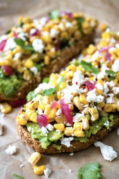 an open face sandwich with corn, feta cheese and cilantro on top