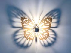 a light that is on the side of a wall with a butterfly shaped light in it