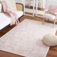 a living room with a white couch and pink rug