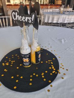 there are two bottles on the table with yellow confetti around them and mickey mouse signs