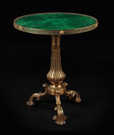 an ornately decorated table with green glass top