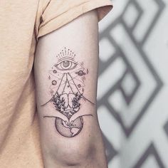 a woman's arm with an all seeing tattoo on it