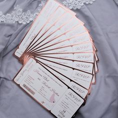 a bunch of tickets sitting on top of a bed next to a lace covered pillow