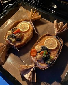 two bags filled with food sitting on top of a stove