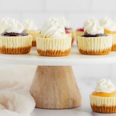 small cupcakes with white frosting and chocolate toppings on a cake stand